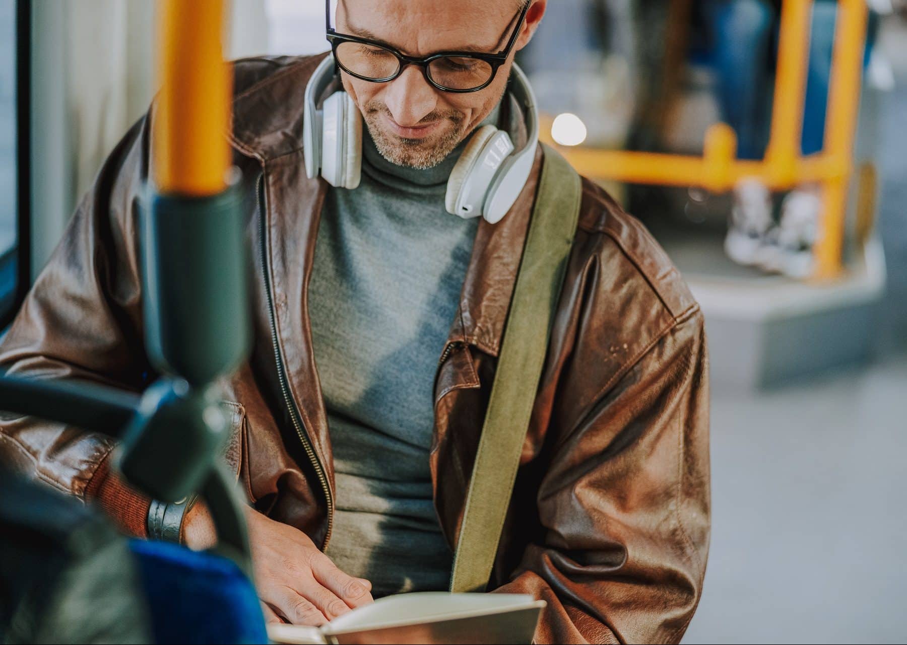 man reading book on bus